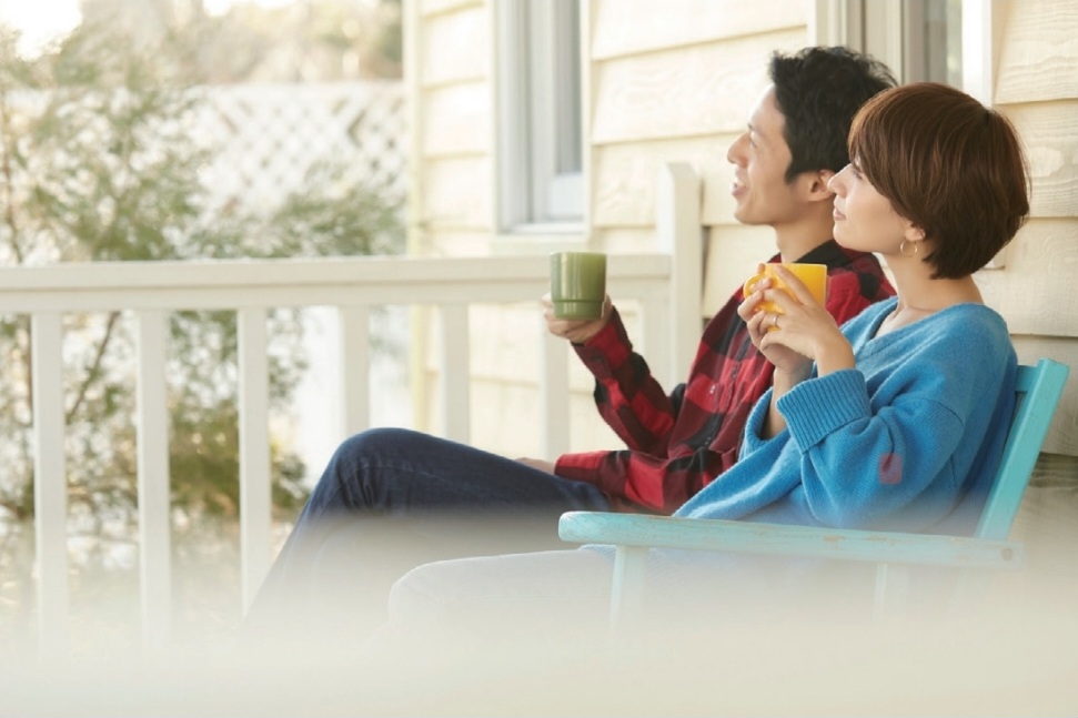 庭のベンチでパートナーとドリンクを楽しむ様子