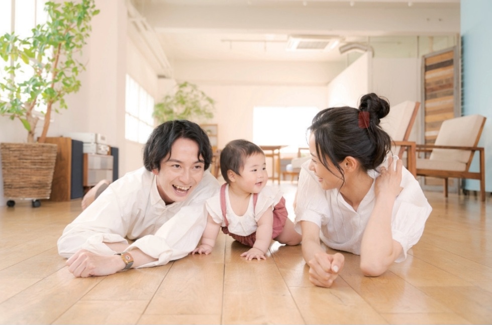 リビングで家族が床でくつろいでいる様子