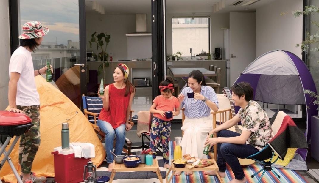 新築住宅のウッドデッキで家族が食事を楽しむ様子