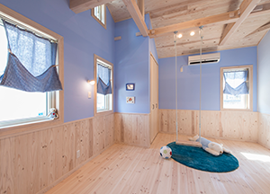 天井と床に木材をふんだんに使い、壁はパステルブルーのクロスで仕上げたキッズルーム